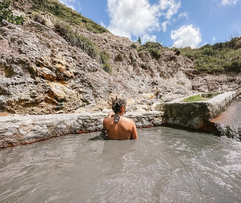 Guest soaking in a Sulphur Springs mud bath in Soufrière